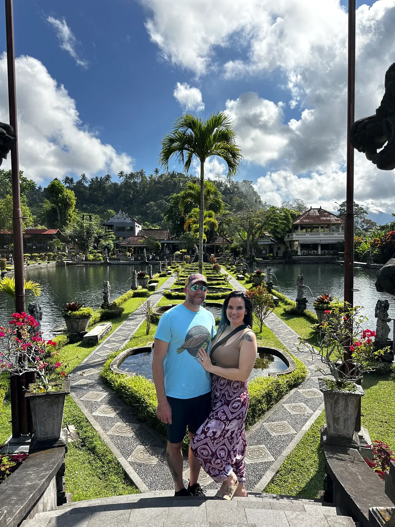 A couple posing in the geometric gardens of a water palace in East Bali