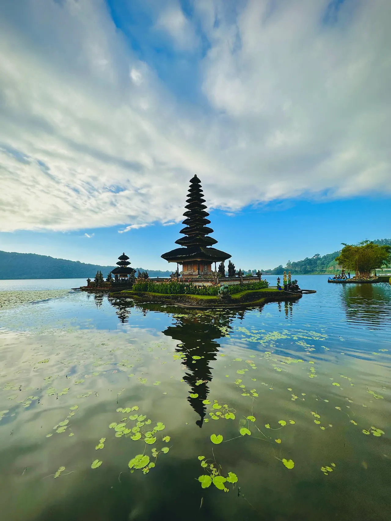 A tiered shrine on a still highland lake reflected in the water